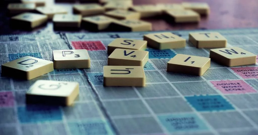 Close-up of Scrabble board with lettered tiles on it.