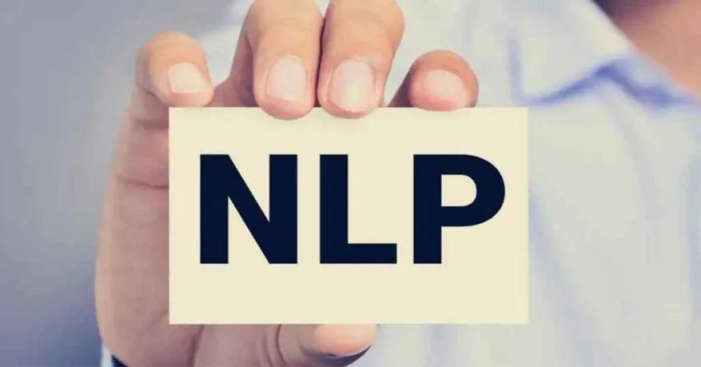 Man holding a card with the word "NLP" written on it